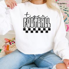 Perfect for any tiger fan! Show your school spirit with this awesome sweatshirt! 50/50 Cotton & Polyester Blend. Gildan Brand Fit: All shirts are unisex fit, true to size, loose fit. Recommend going up 1-2 sizes for an oversized look. Please check the size chart. If you have any questions, please contact us. Please check your address to make sure it is your current address. Care Instructions:  For the best and lasting results, wash in cold water inside out. No bleach. Dry on low heat or hang dry School Spirit Sublimation Crew Neck For Sports Season, Team-colored Sweatshirt With Letter Print For School Spirit, Team-colored Letter Print Sweatshirt For School Spirit, White School Spirit Sweatshirt, Game Day School Spirit Sublimation Crew Neck, College Sweatshirt With Graphic Print For School Spirit, White School Spirit Sweatshirt For Fan Gear, White School Spirit Sweatshirt For Sports, White School Spirit Sweatshirt For College