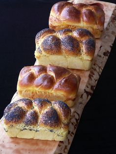 four pieces of bread sitting on top of a wooden cutting board next to each other