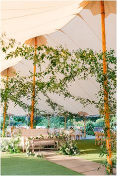 an outdoor dining area with tables and umbrellas on the roof, surrounded by greenery