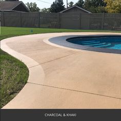 an empty swimming pool in the middle of a yard with grass and fence around it