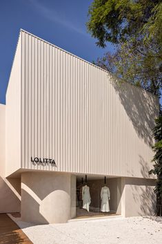 two mannequins are displayed in front of a white building with the word hollata written on it