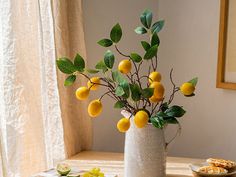 a vase filled with lemons sitting on top of a table next to crackers