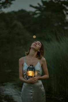 a woman holding a lantern in her hands