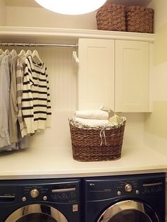 a washer and dryer in a laundry room with clothes hanging on the rack