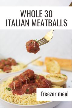 a plate with spaghetti and meatballs on it that is being lifted by a fork