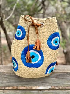 Delve into the enchanting world of mystique with our Evil Eye Embroidered Backpack, where artistry and legend intertwine. Handcrafted with precision by skilled Mexican artisans, this boho backpack features an evil eye embroidered design that offers protection and adds a whimsical charm to your outfit. Its vibrant and colorful motifs are a nod to traditional symbols that invite positivity and ward off negativity. This straw backpack not only captivates with its aesthetic appeal but is also practi Bohemian Natural Color Backpack, Straw Backpack, Bohemian Backpack, Bucket Design, Boho Backpack, Embroidered Backpack, Handcrafted Boots, Painted Hats, Colorful Backpacks