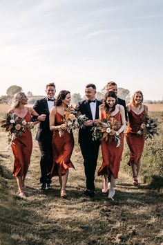 a group of people standing next to each other on top of a grass covered field