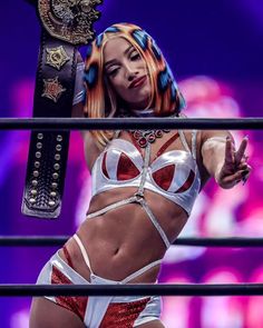 a woman in a wrestling ring holding a belt