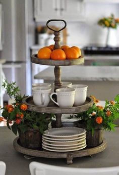 a tray with oranges and cups sitting on top of it in the middle of a kitchen