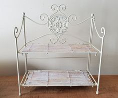 a white metal shelf sitting on top of a wooden floor