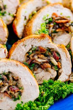 sliced pork loin with mushrooms and parsley on blue platter, closeup