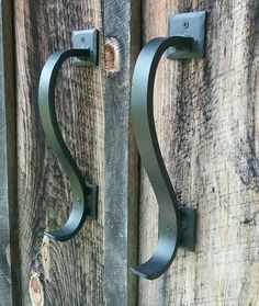 two metal hooks are attached to wooden boards