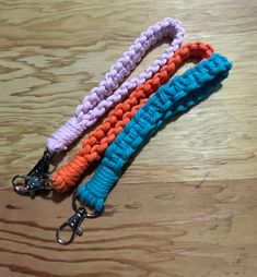 three crocheted lanyards are on a wooden table