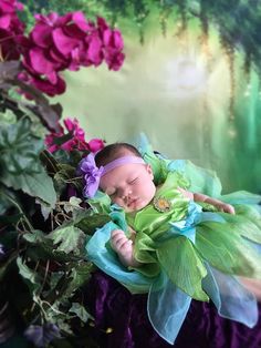 a baby sleeping on top of purple flowers