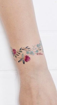 a woman's foot with a flower tattoo on it