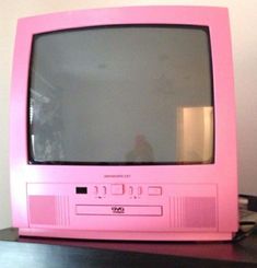 a pink television sitting on top of a wooden table