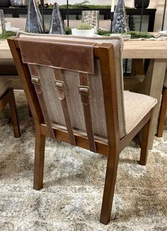 a dining room table and chairs with christmas decorations on the top shelf in the background