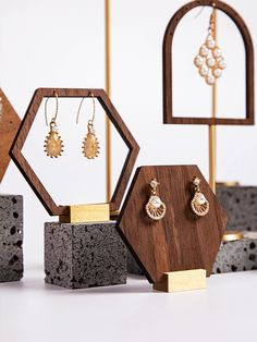 three wooden jewelry stands with earrings on them