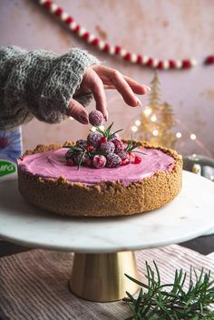 a person placing berries on top of a cake