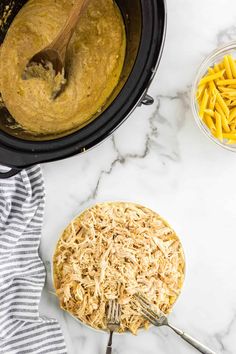 an image of macaroni and cheese being cooked in the crock pot with a wooden spoon