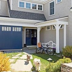 two dogs standing in front of a house with a bicycle parked on the side walk