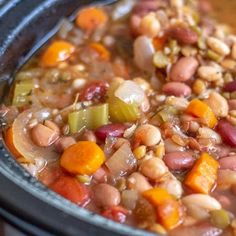 a bowl filled with beans and carrots on top of a table