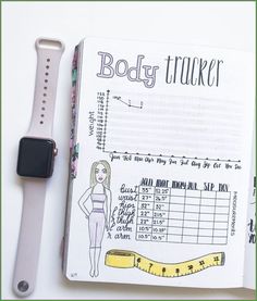 an apple watch and a notebook with the body tracker on it, next to a measuring tape