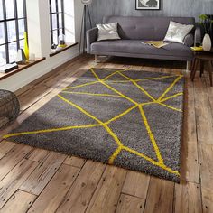 a living room with wooden floors and gray furniture