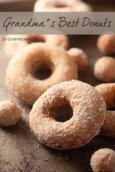 some sugared doughnuts are sitting on a table with the words grandma's best donuts