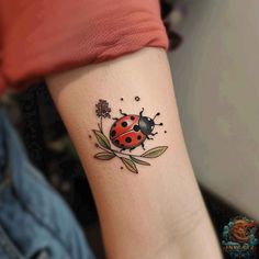 a ladybug tattoo on the wrist