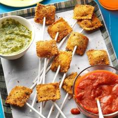 appetizers with toothpicks and dipping sauces on a blue tablecloth