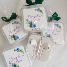 there are four place settings in plastic bags with flowers and ribbons on the top, along with two forks and spoons