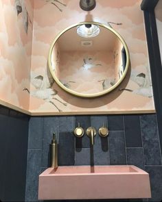 a bathroom with a pink sink and gold faucet in the middle of it