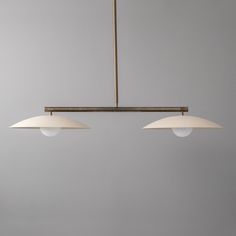 three lights hanging from a ceiling fixture in a room with gray walls and flooring