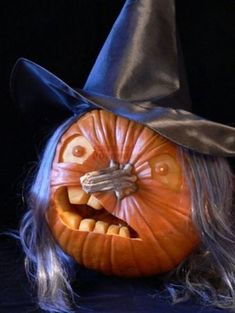 a halloween pumpkin with a witch's hat on its head and long gray hair