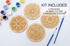 four wooden coasters with paint and brushes next to them