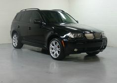 a black bmw suv parked in a garage