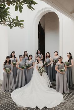 a group of women standing next to each other in front of a white wall and doorway