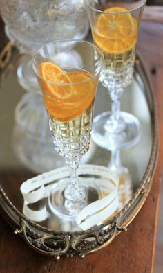 two glasses filled with orange juice on top of a tray