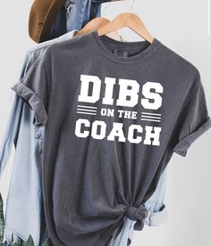 Dibs on the coach! This is a unisex short sleeve T-shirt in grey! The image on the shirt is made from red, white or black vinyl! Care instructions will be included with your package! These shirts will last! You will have the option to choose the color vinyl and size at checkout. If you have any questions or would like to change anything on the shirt please send me a message! Dibs On The Coach Shirt, Football Coach Wife, Coaches Wife Shirt, Dibs On The Coach, Coach Tshirts, Cheer Coach Shirts, Coaches Wife, Dance Coach, Coach Shirt