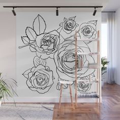 a black and white floral wall mural in a living room with wooden floors, a ladder and potted plant