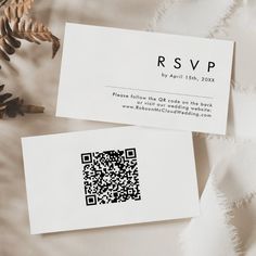 two business cards with qr code printed on them next to pine cones and leaves