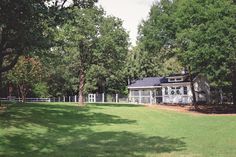 a white house surrounded by trees and grass