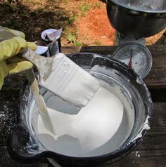 a person in yellow gloves is cleaning an old metal bucket with a cloth on it