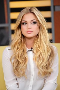 a woman with long blonde hair sitting down