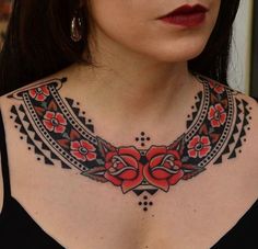 a woman wearing a black top with red flowers on her chest