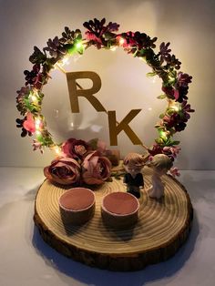 a wooden table topped with two cakes and cupcakes next to a sign that says rk