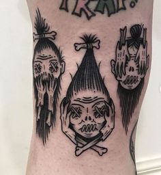 a man with tattoos on his leg has three skulls and a clown's head