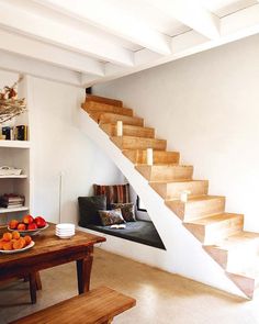 there is a room with stairs and books on the shelves next to the table in front of it