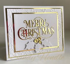 a christmas card with the words merry christmas written in gold and silver on white paper